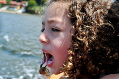 Close-up of girl shouting against sea