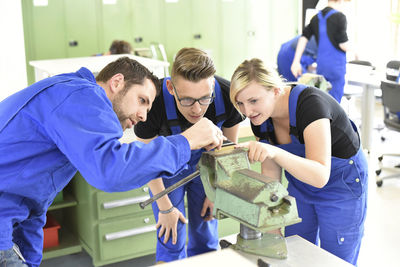 Instructor with trainees at workbench