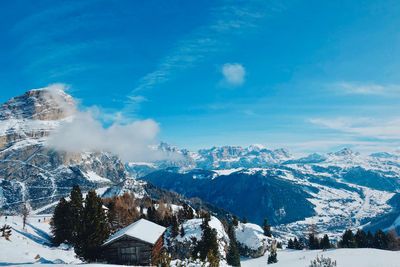 Aerial view of snowcapped mountains against blue sky