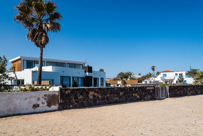 Houses and trees against clear blue sky