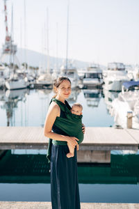 Woman standing on railing against water