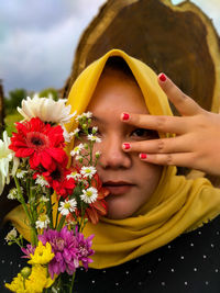 Close-up portrait of woman with red flower