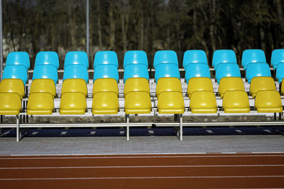 A fragment of the grandstand of an sports stadium with ukrainian flag color - blue and yellow- seats