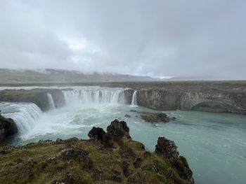 Scenic view of waterfall against sky