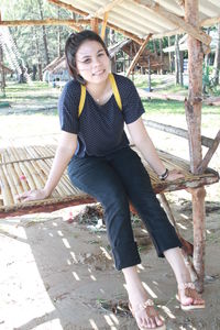 Portrait of smiling young woman sitting outdoors