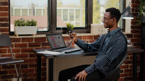 Smiling businessman talking on video call at office