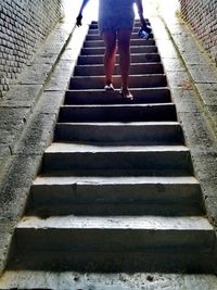 Low section of woman walking on staircase