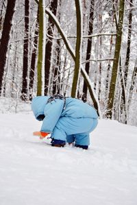 Boy in snow covered forest