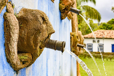 Close-up of old fountain sculpture against building