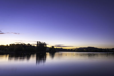 Scenic view of river against clear sky at sunset