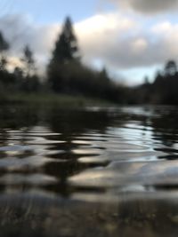 Surface level of lake against sky during sunset