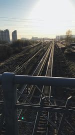 Railroad tracks in city against sky