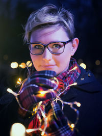 Close-up portrait of woman holding illuminated lights