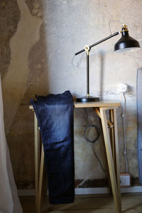 Modern interior and pair of blue jeans, lamp and wall