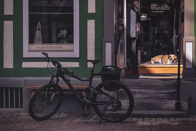 Bicycle parked on street against building