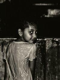 Portrait of wet girl standing outdoors at night 