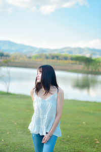 Side view of woman standing against lake