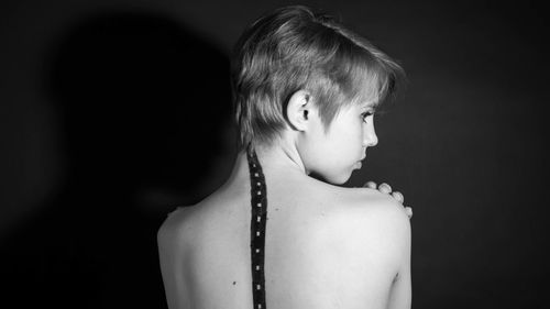 Portrait of girl looking away against black background