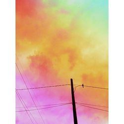 Low angle view of electricity pylon against sky during sunset