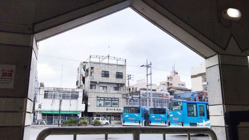 Buildings against sky seen through train window