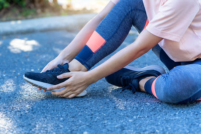 Low section of man using mobile phone in city