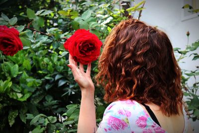 Rear view of woman with red flower