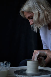 Ceramist works behind a potter's wheel