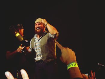 Low angle view of man holding camera at night