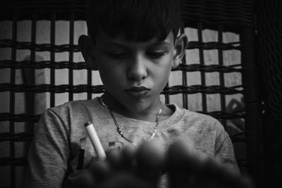 Close-up of boy looking through window