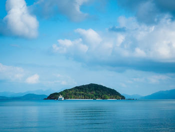 Scenic view of koh kham in peaceful bay against cloudy blue sky. shot from koh mak island, thailand.