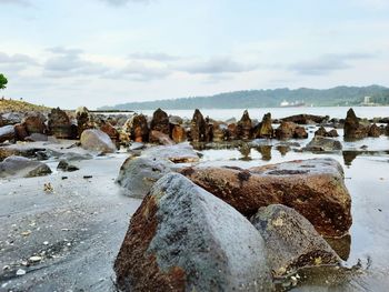 Rocks on shore against sky during winter