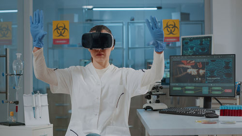 Female scientist gesturing while using vr in lab