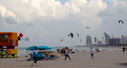 People enjoying at beach against sky