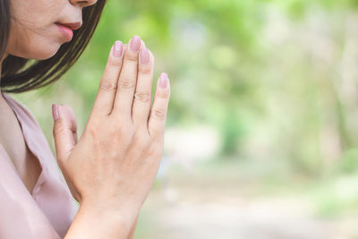 Midsection of woman touching leaf