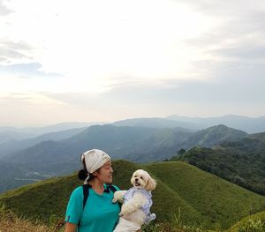 Full length of young woman with horse in mountains against sky