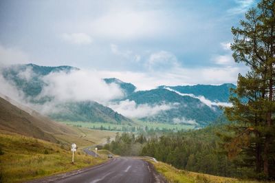 Road leading towards mountains against sky