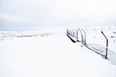 Scenic view of snow covered field against sky