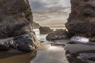 Rock formations in sea against sky