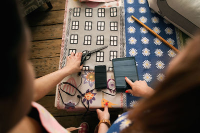 Owner showing and pointing on digital tablet while working at fabric shop