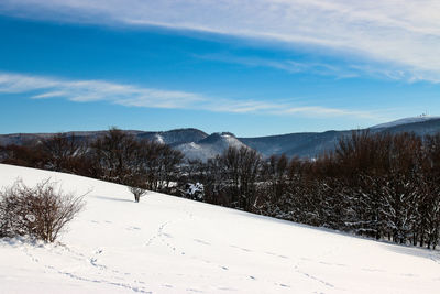 Snow covered landscape against sky