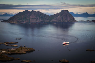 Scenic view of sea by mountains against sky