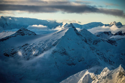 Dramatic sky above snow covered mountain peaks around mount sonnblick, austria.