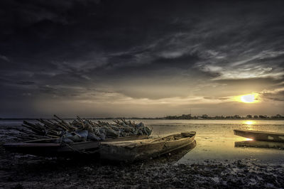 Boats moored on sea against sky during sunset