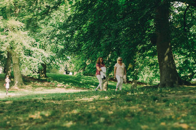 Women standing by trees in park