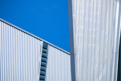 Low angle view of modern building against clear blue sky