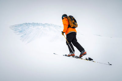 Winter skitour freeride in cloudy weather, snow-capped mountains against the backdrop of a glacier