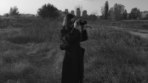 Woman photographing on field