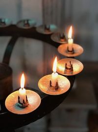 Close-up of illuminated candles on stand