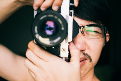 Close-up of man photographing with camera