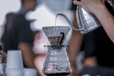 Close-up of person pouring coffee in cafe